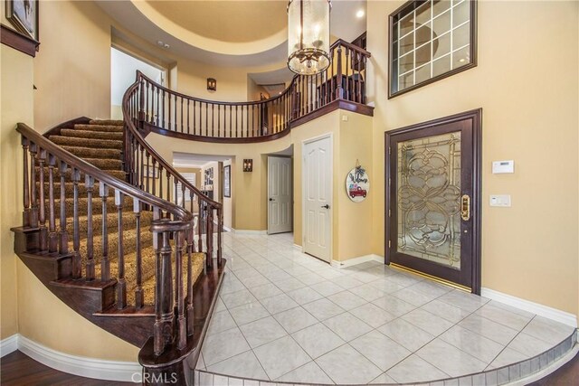 880 E 24th St, Upland, CA 91784 - foyer with baseboards, stairs, tile patterned flooring, a chandelier, and a high ceiling