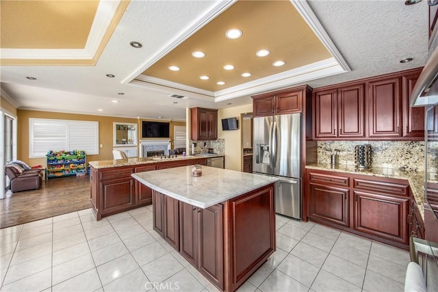 880 E 24th St, Upland, CA 91784 - kitchen with appliances with stainless steel finishes, a raised ceiling, crown molding, open floor plan, and a peninsula