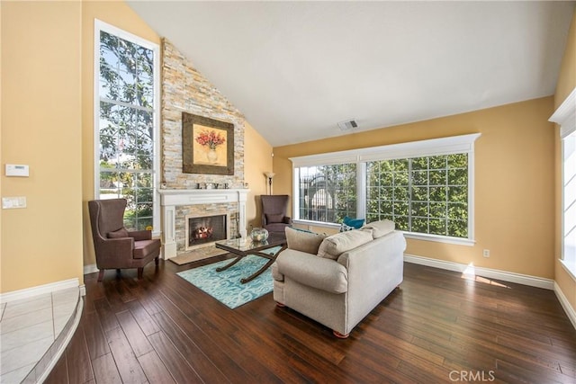 880 E 24th St, Upland, CA 91784 - living room with a stone fireplace, dark wood-style flooring, vaulted ceiling, and baseboards