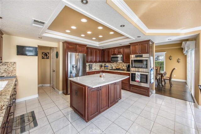 880 E 24th St, Upland, CA 91784 - kitchen with a tray ceiling, appliances with stainless steel finishes, backsplash, crown molding, and light tile patterned floors