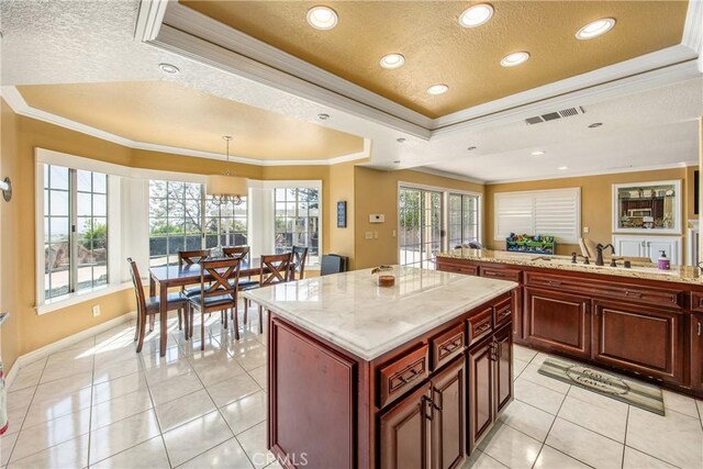 880 E 24th St, Upland, CA 91784 - kitchen with a raised ceiling, crown molding, a textured ceiling, a kitchen island, and light tile patterned floors