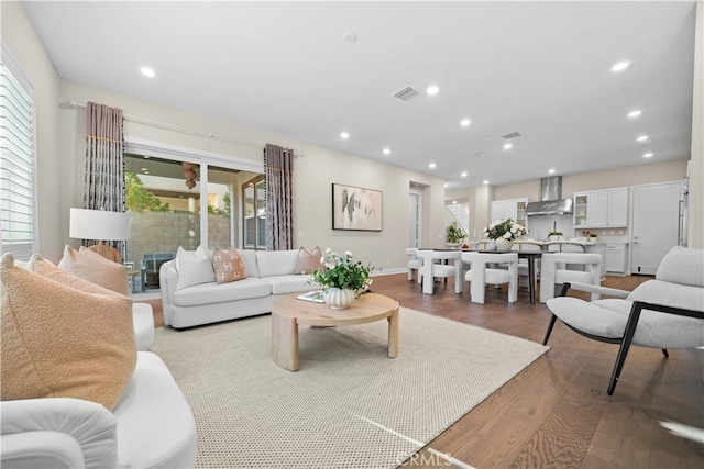 living area with recessed lighting, visible vents, and wood finished floors