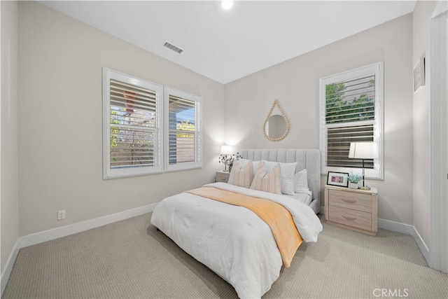 bedroom featuring visible vents, baseboards, and light colored carpet