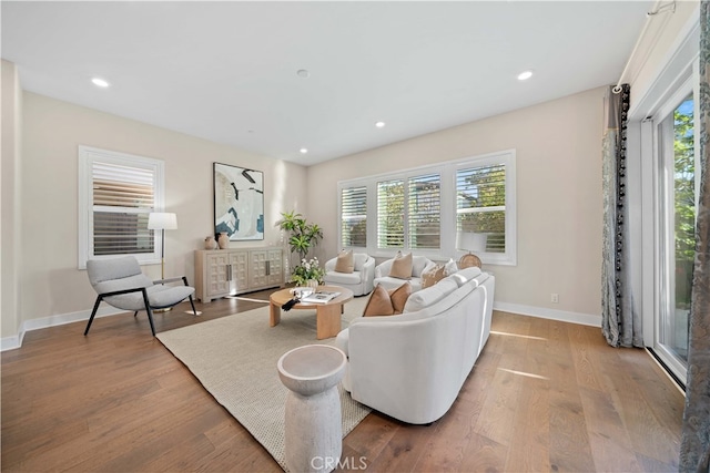 living room featuring baseboards, recessed lighting, and wood finished floors