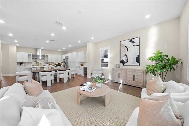 living area with recessed lighting, visible vents, baseboards, and wood finished floors