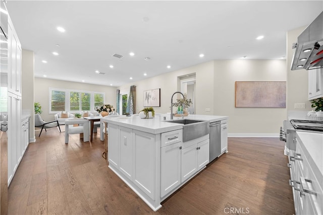 kitchen with recessed lighting, white cabinetry, dark wood finished floors, stainless steel dishwasher, and a sink