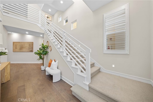 stairs featuring recessed lighting, baseboards, and wood finished floors