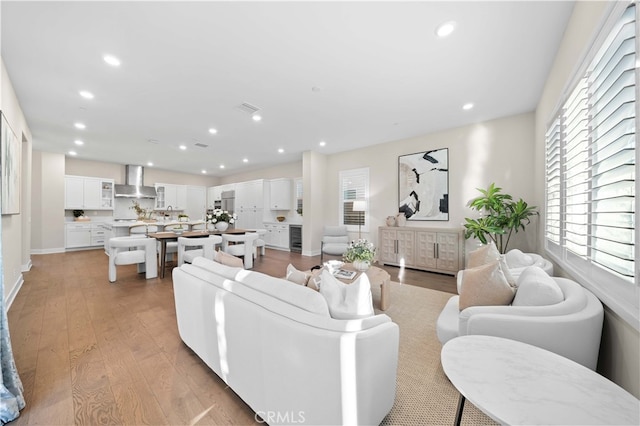 living area with light wood-style flooring, wine cooler, visible vents, and recessed lighting