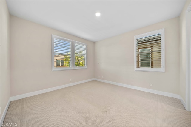 carpeted empty room featuring baseboards