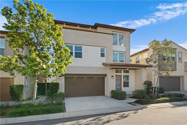 contemporary house featuring concrete driveway, stucco siding, and a garage