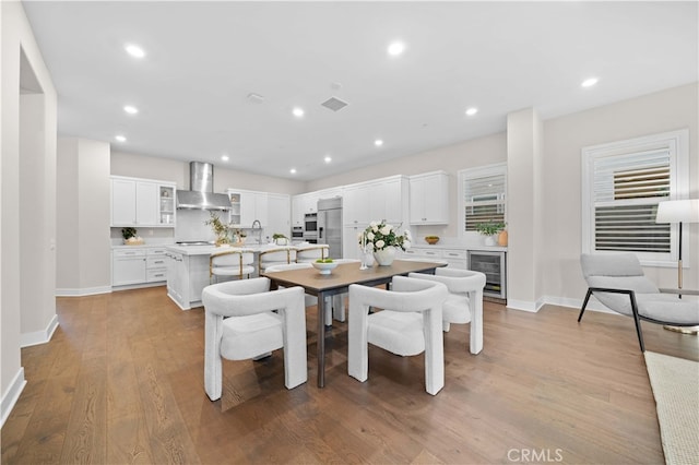 dining room with visible vents, baseboards, recessed lighting, wood finished floors, and beverage cooler
