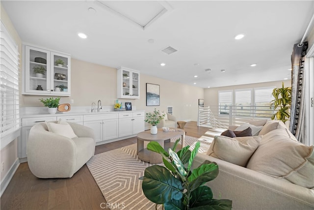 living room with visible vents, recessed lighting, and wood finished floors