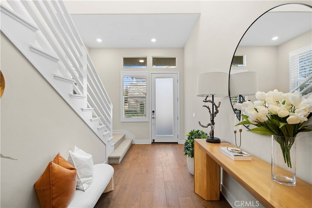 foyer entrance with wood finished floors, recessed lighting, baseboards, and stairway