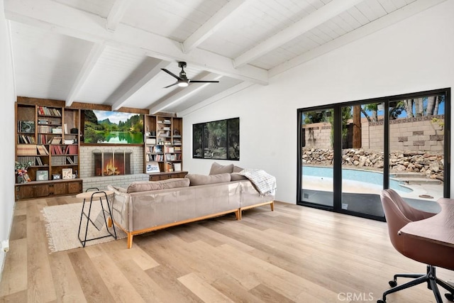 living room featuring a fireplace, ceiling fan, vaulted ceiling with beams, and wood finished floors