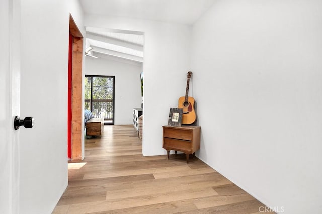 corridor featuring light wood finished floors and vaulted ceiling