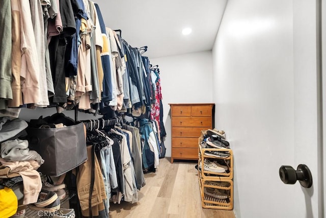 walk in closet with light wood-style flooring
