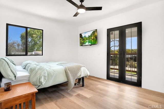 bedroom with light wood-type flooring, multiple windows, access to exterior, and french doors