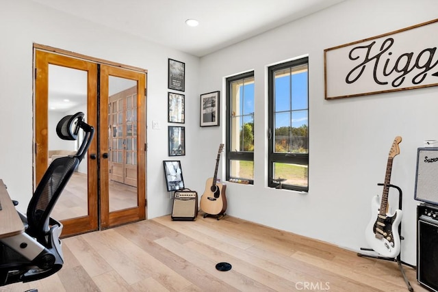office with light wood-style floors, recessed lighting, and french doors