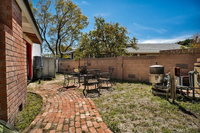 view of yard featuring outdoor dining space, a fenced backyard, and a patio area