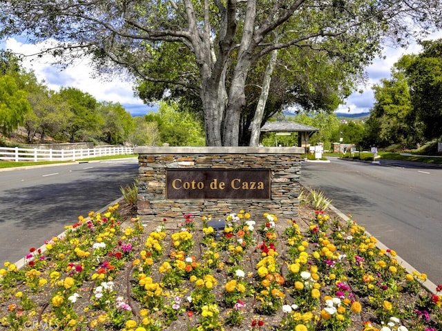 community / neighborhood sign featuring fence
