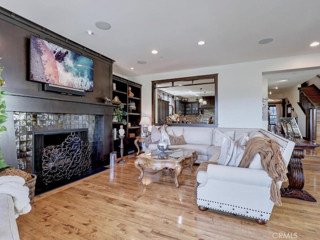 living room featuring wood finished floors, a fireplace, and recessed lighting