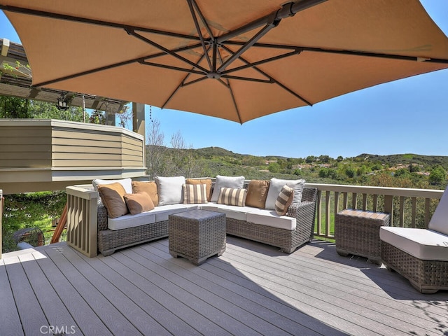 wooden terrace featuring a mountain view and an outdoor hangout area