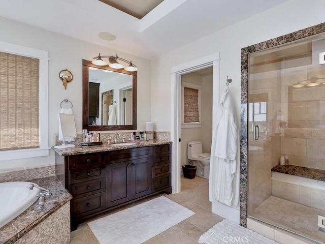 full bathroom featuring a shower stall, a garden tub, vanity, and toilet