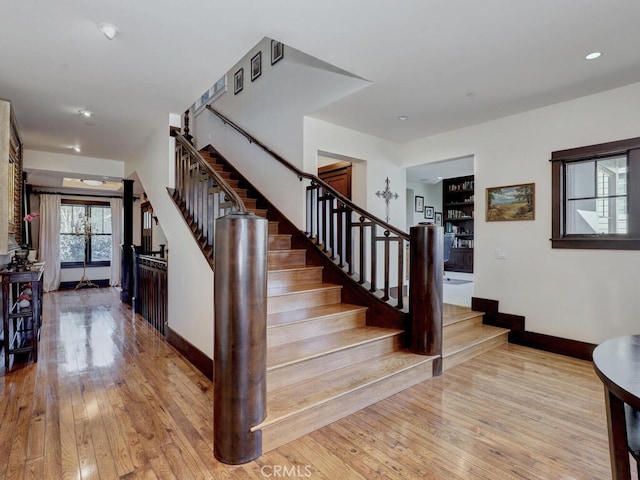 staircase with hardwood / wood-style floors, baseboards, and recessed lighting