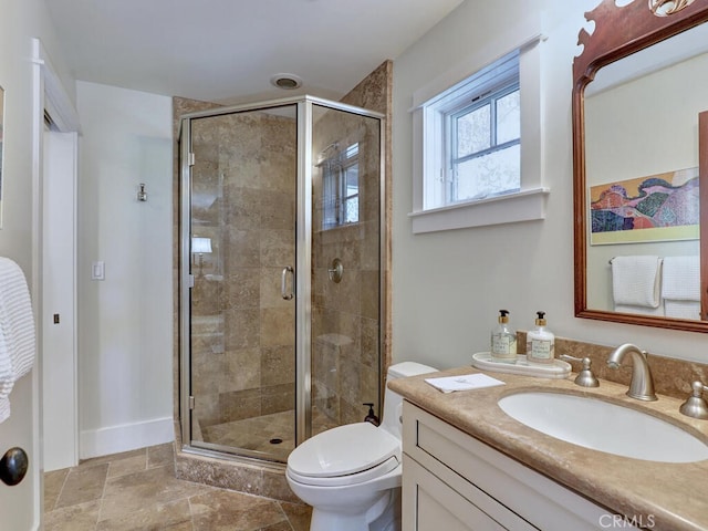 full bath with stone finish flooring, toilet, vanity, and a stall shower