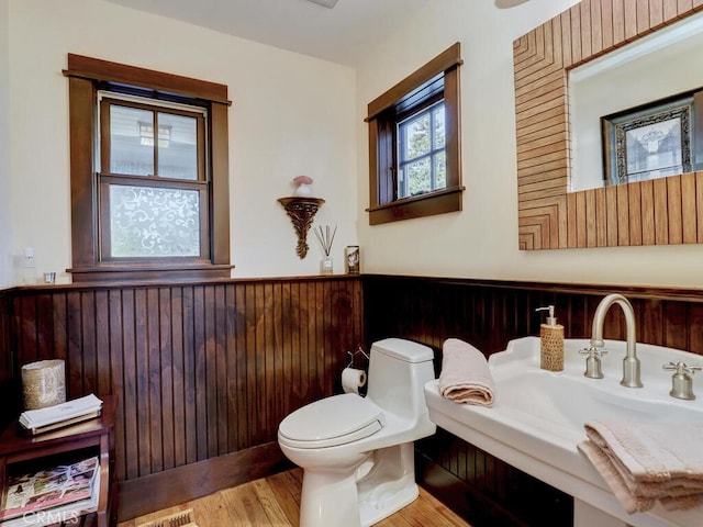 half bathroom featuring a sink, toilet, and wood finished floors