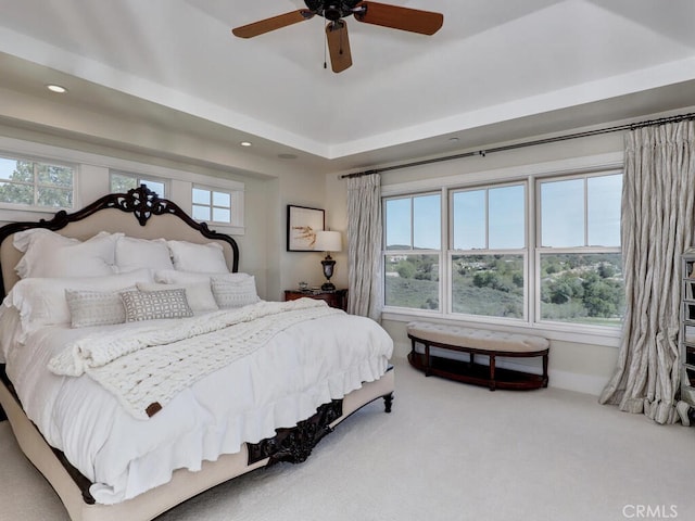 carpeted bedroom with recessed lighting, a raised ceiling, and a ceiling fan