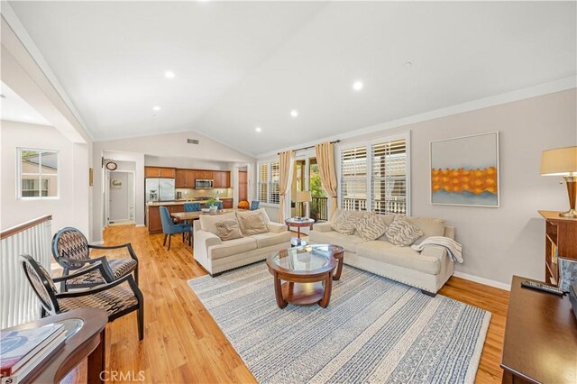 35 Jonquil, Irvine, CA 92618 - living area featuring light wood-style flooring, vaulted ceiling, baseboards, and recessed lighting