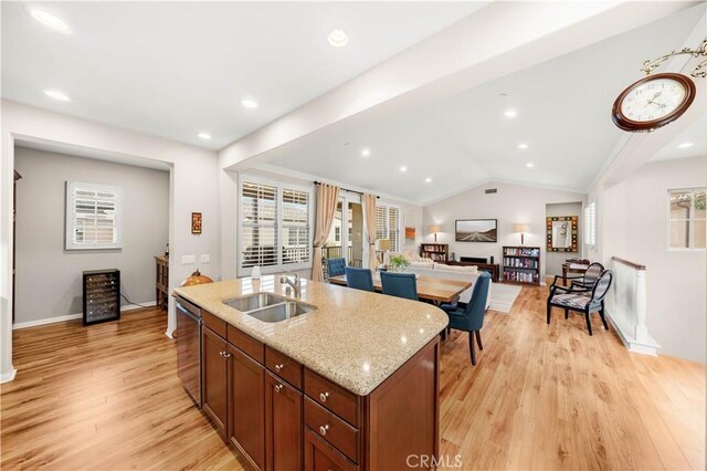 35 Jonquil, Irvine, CA 92618 - kitchen featuring a sink, dishwasher, light wood-type flooring, vaulted ceiling, and a center island with sink