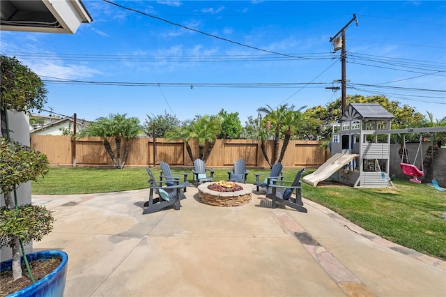 view of patio featuring a fenced backyard, an outdoor fire pit, and a playground
