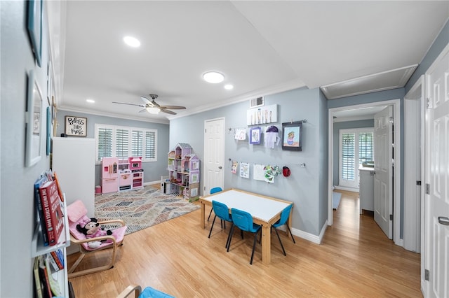 playroom featuring crown molding, light wood finished floors, baseboards, and visible vents