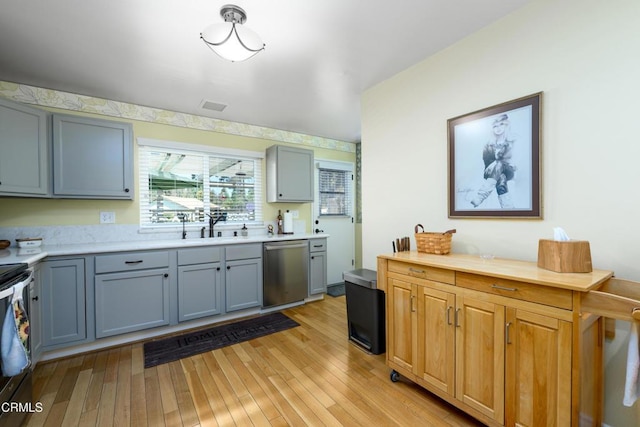 28210 Village 28, Camarillo, CA 93012 - kitchen with light countertops, stainless steel dishwasher, light wood-style flooring, and a sink