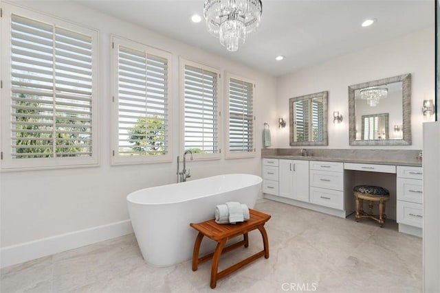 full bathroom featuring baseboards, an inviting chandelier, recessed lighting, vanity, and a freestanding bath