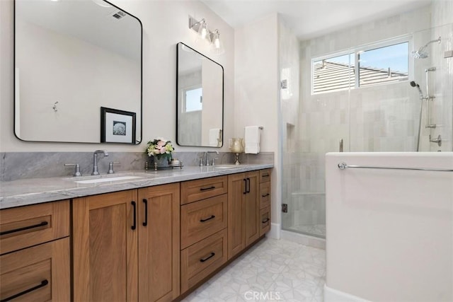 bathroom featuring double vanity, tile patterned flooring, a stall shower, and a sink