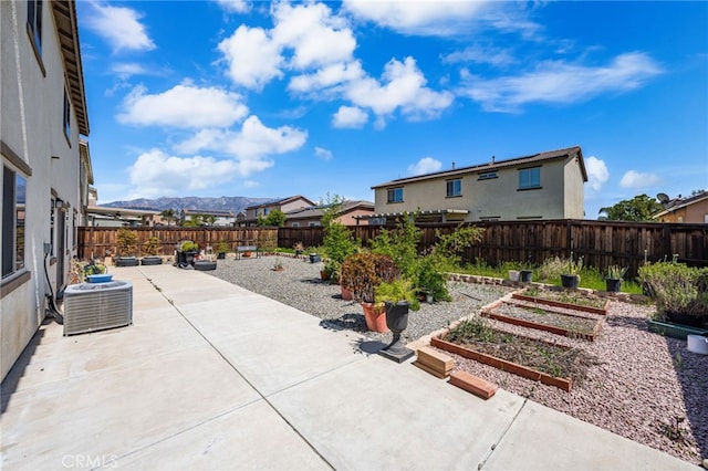 view of patio featuring a garden, a fenced backyard, cooling unit, and a mountain view