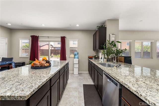 kitchen with baseboards, dishwasher, a sink, recessed lighting, and light stone counters