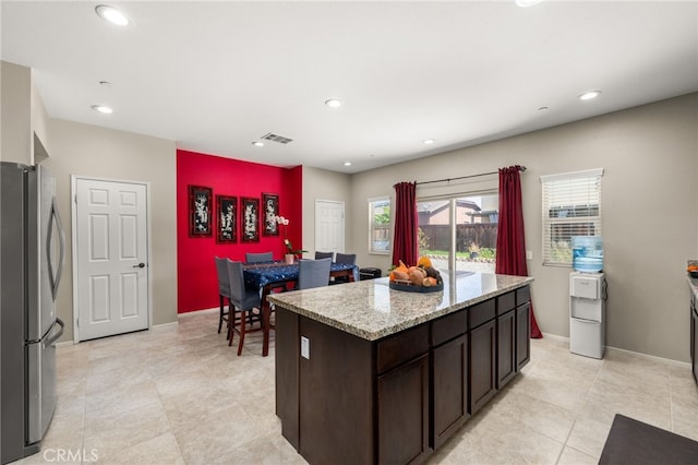 kitchen featuring recessed lighting, visible vents, freestanding refrigerator, and dark brown cabinets