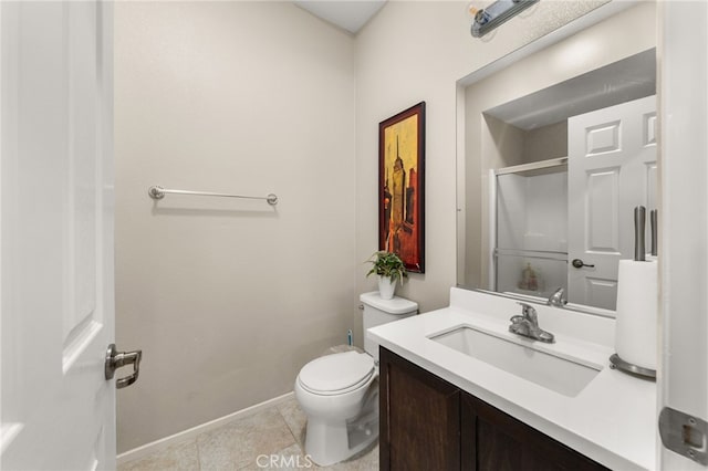 bathroom featuring baseboards, toilet, vanity, tile patterned floors, and a shower with door
