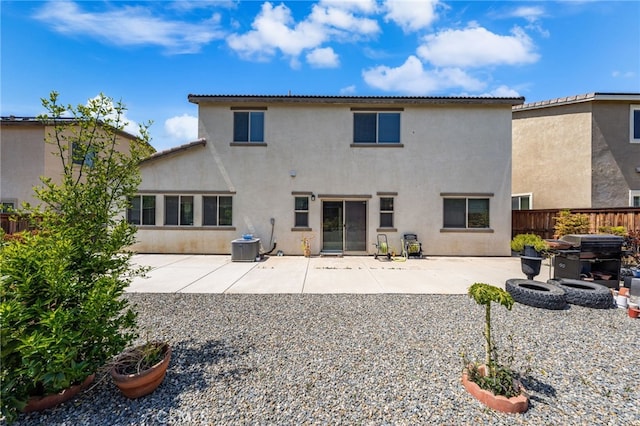 back of house with central AC unit, a patio area, stucco siding, and fence