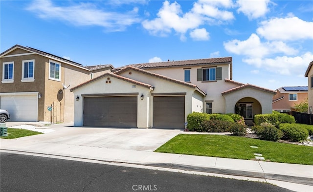 mediterranean / spanish-style home with stucco siding, a front yard, a tile roof, a garage, and concrete driveway