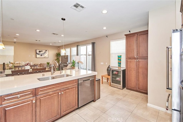 kitchen featuring visible vents, dishwasher, a sink, light countertops, and wine cooler