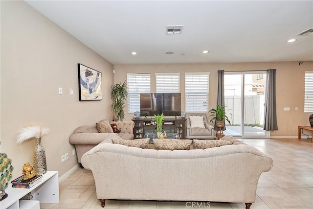 living area featuring a wealth of natural light, recessed lighting, and visible vents