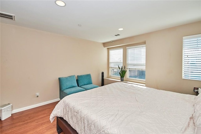 bedroom featuring recessed lighting, visible vents, baseboards, and wood finished floors