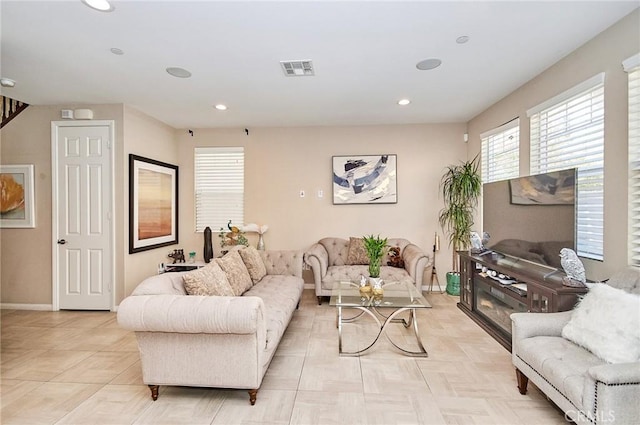 living area featuring baseboards, visible vents, and recessed lighting