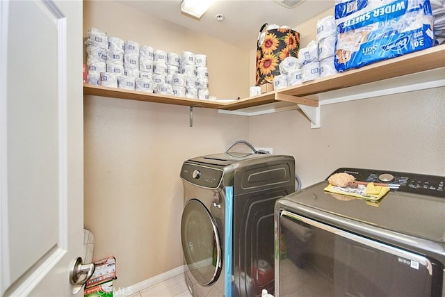 washroom with light tile patterned floors, separate washer and dryer, and laundry area