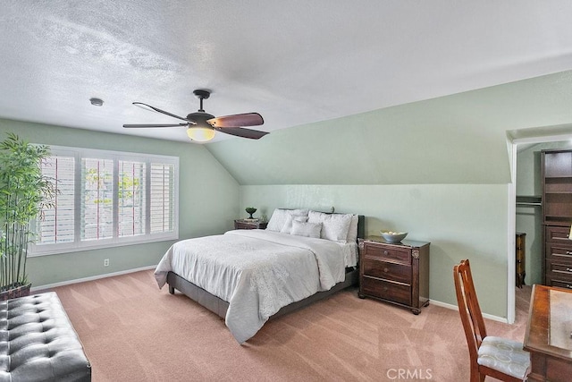 bedroom with a textured ceiling, light colored carpet, baseboards, and lofted ceiling